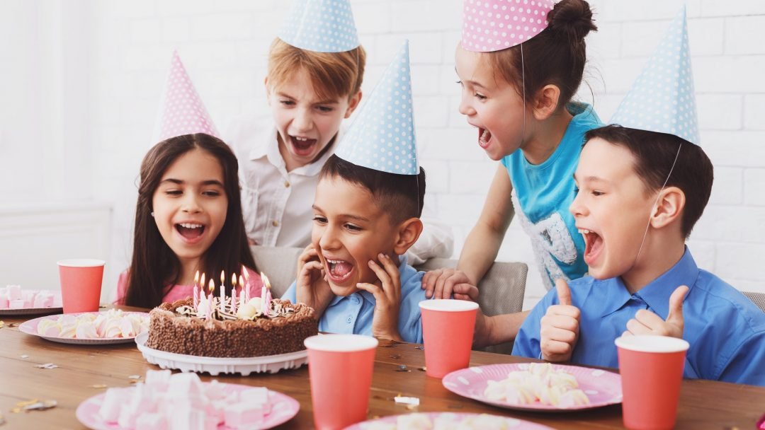 kids-birthday-party-boy-blowing-out-candles-on-cake-1.jpg